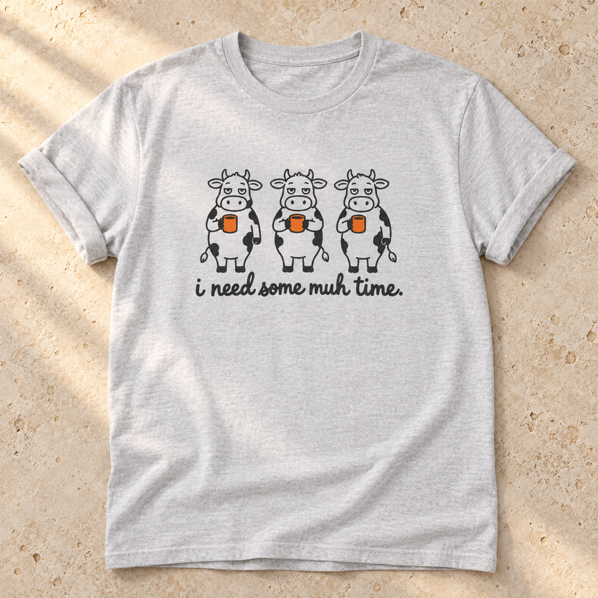 I Need Some Muh Time – Unisex Kuh-T-Shirt in Ash – natürliches Flatlay mit aufgekrempelten Ärmeln