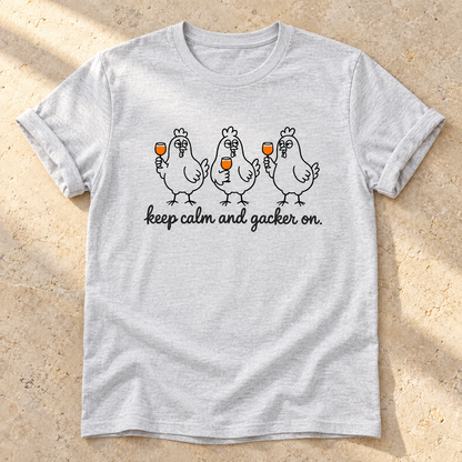 Keep Calm and Gacker On – Unisex Hühner-T-Shirt in Ash – natürliches Flatlay mit aufgekrempelten Ärmeln