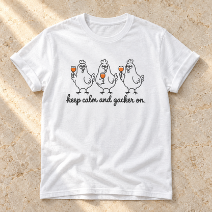 Keep Calm and Gacker On – Unisex Hühner-T-Shirt in White – natürliches Flatlay mit aufgekrempelten Ärmeln