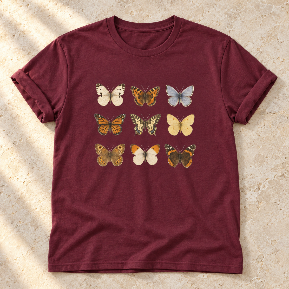 Schmetterlinge – Unisex Vintage-T-Shirt in Maroon – natürliches Flatlay mit aufgekrempelten Ärmeln