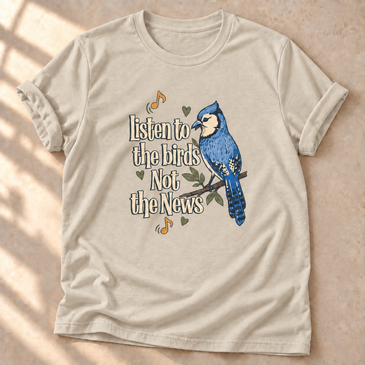 Listen to the Birds Not the News – Vogel-T-Shirt in sand, natürliches Produktmockup